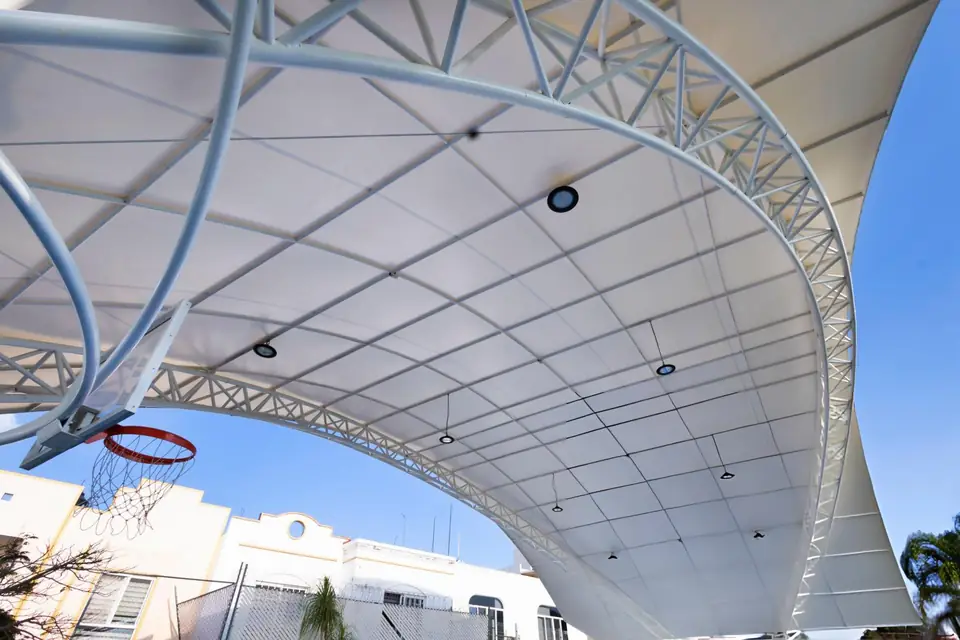 Penutup membrane dengan rangka truss melengkung dan lampu menaungi lapangan basket